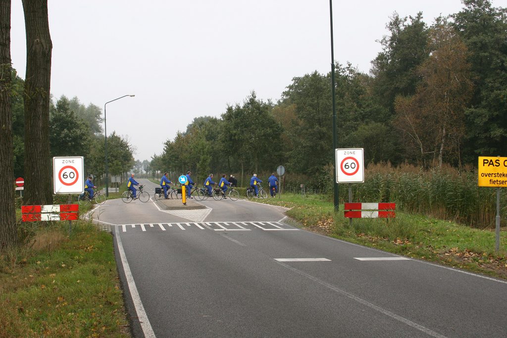 Spurwechsel bei Radwegen. Auf der gelben Tafel rechts steht: «Aufpassen! Velofahrer überqueren die Fahrbahn!»