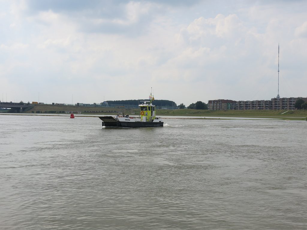 Die Fussgängerfähre kämpft sich über den Hochwasser führenden Lek