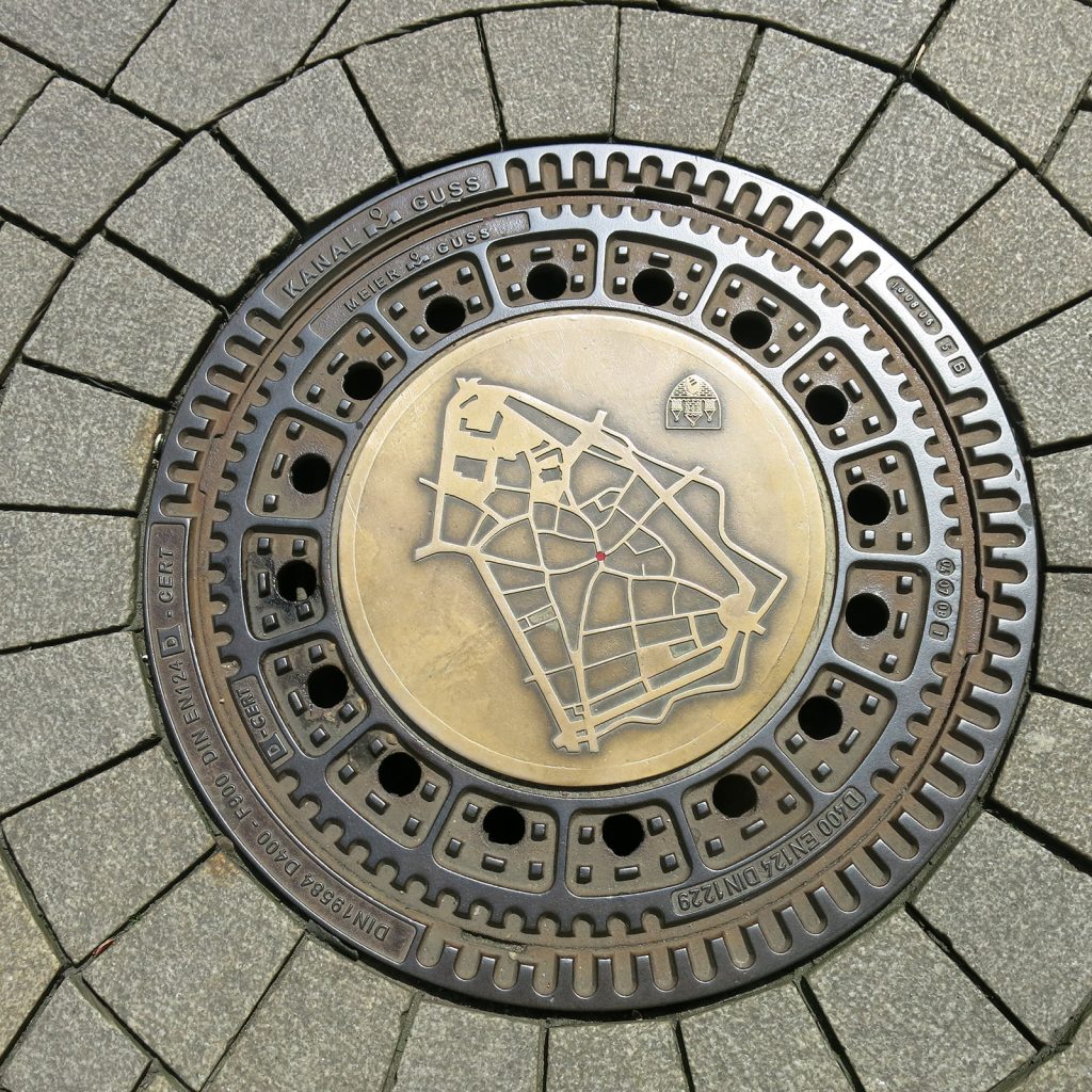 Grundriss der Altstadt auf einem Gully-Deckel (Standort ist der rote Punkt)